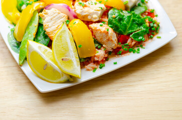 A plate of food with a yellow lemon and green peas