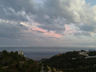 Evening  view of Altea Hills, Spain, hills, houses, villas, trees, the Mediterranean Sea, clouds, dramatic sky, urbanization