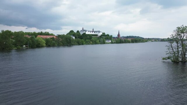Drone view of a small island overpopulated by cormorants and covered with faeces in a lake near Ploen.