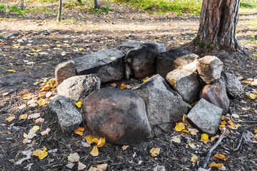 The area where we had a fire in the autumn forest was surrounded by stones to protect the environment.