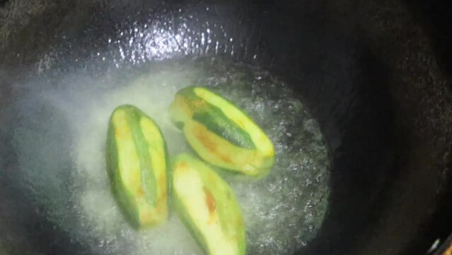 Close-up video of pointed gourd, parwal/parval (patol) frying in pan.4k. Pointed gourd potato curry, Indian food.