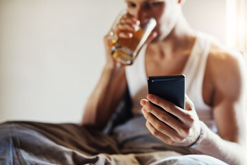 Phone, internet and man in bed with tea, social media update and morning in home with mockup. Male person, mobile and drink cup for sms app notification, relax and reading email with promotion space