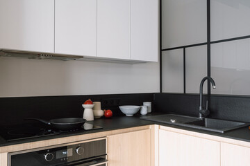 Modern kitchen with built in appliances and black marble countertop