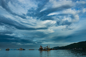 ships on the sea with cloud that looks like a tornado forming