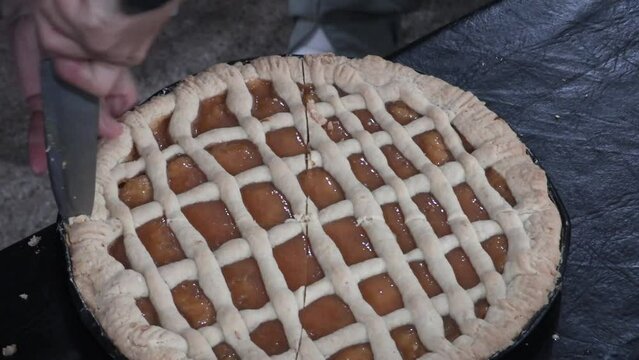 Woman cutting a homemade sweet cake. Cook cutting a sweet potato frola paste. Traditional Argentine cake.  Argentine pie. 