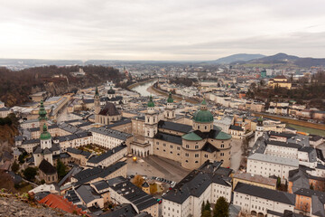 Panoramic view of the old town from the Hohensalzburg fortress. Cloudy and gloomy winter day, St. Peter's Abbey and Baroque Salzburg Cathedral