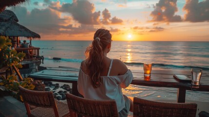 Woman enjoying sunset view from a beachside cafe