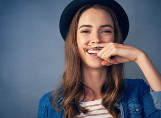 Portrait, happy and female model with finger mustache in studio for modern fashion, stylish or...