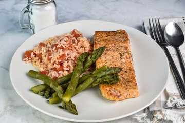 baked seasoned salmon served with asparagus and rice,