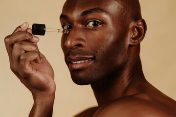 Happy African American man holding a serum bottle, smiling and showcasing skincare product against a soft light background