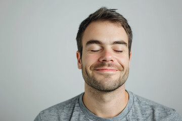 A man with a relaxed smile and closed eyes, completely isolated from the environment, set against a plain white background