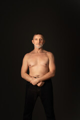 Fototapeta premium elderly man with a beard, a handsome torso and in good physical shape. Healthy lifestyle. Selective focus