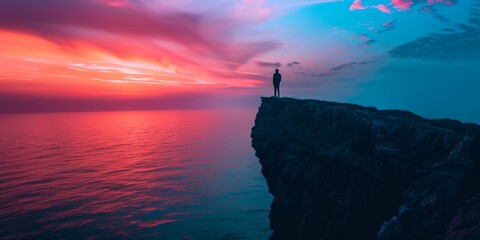 A dramatic seaside cliff at sunset, with the silhouette of a person standing at the edge, gazing out over the brightly colored horizon