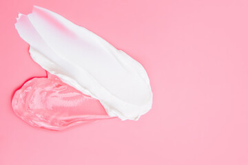 Gel and cream smears cosmetic texture on pink background with space for text