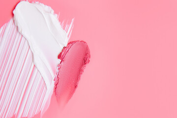 creamy and shimmery cosmetic texture smears on pink background with space for text