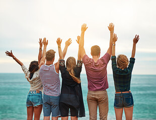 Obraz premium People, back and holiday together with ocean, excited and adventure with friends on weekend or summer break. Happiness, bonding and group or fun gathering in nature, travel vacation or arms stretched