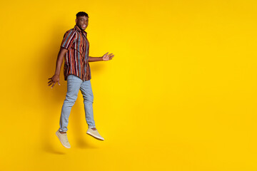 Full size photo of nice young man jump empty space wear shirt isolated on yellow color background