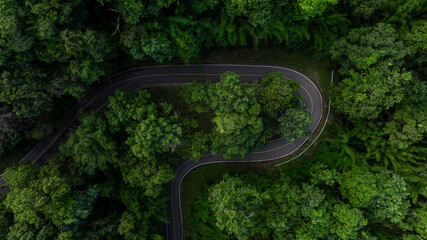 Aerial view asphalt road on green forest, Curve asphalt road on mountain green forest, Countryside road passing green forrest and mountain.