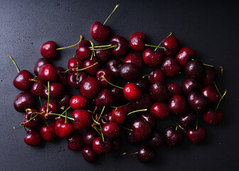 Fresh red cherries fruit. Fresh organic berries with leaves macro. Large collection of fresh red cherries. Ripe cherries background. Lot of red ripe cherries close up with water drops.