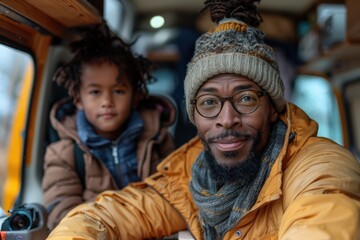 Obraz premium A father in a yellow jacket and beanie shares a bonding moment with his young son in cozy winter clothing inside a vehicle, evoking themes of warmth, connection, and comfort.