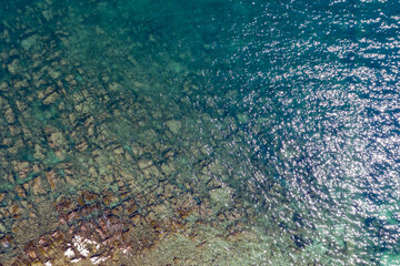 Aerial photo of sea in summer. Beautiful sea seen from above and a rocky bottom at a pebble beach.