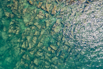 Aerial photo of sea in summer. Beautiful sea seen from above and a rocky bottom at a pebble beach.