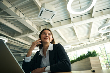 Young lady sitting at her workplace in a jacket