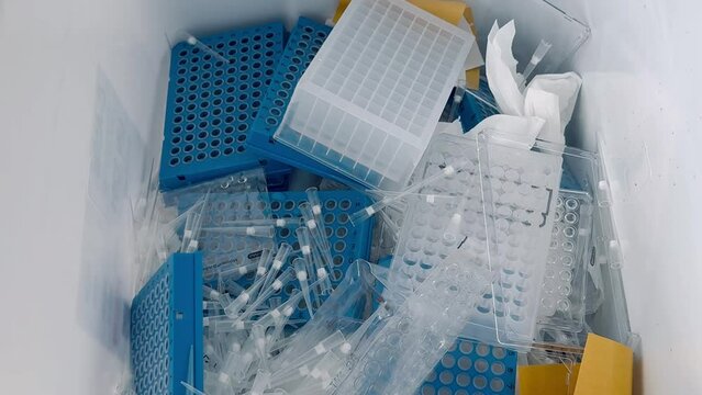Trash filled with medical waste, plastic containers and laboratory supplies. Disposal of medical items and adherence to healthcare protocols. Healthcare, environmental, and waste management contexts