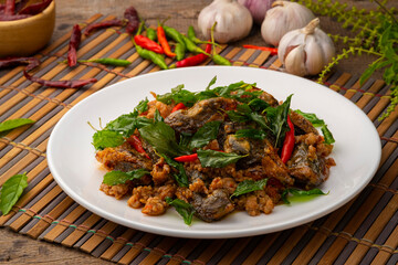 Stir Fried Crispy Basil with Pork and Black Preserved Egg in white plate (Kai Yiew Ma Kra Prao Krob)