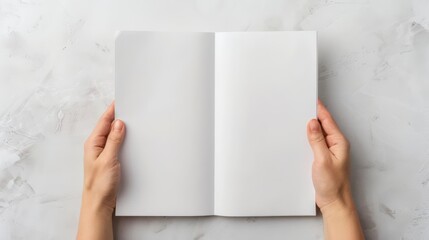 Person holds an open blank notebook revealing empty white pages, ideal for concepts of creativity, journaling, or note-taking.