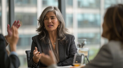 Obraz premium Senior businesswoman leading a conversation in a professional meeting