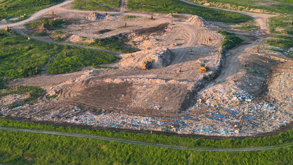 AERIAL: Municipal garbage dump with waste burial and partially restored landfill
