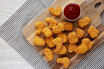 Crunchy Chicken Nuggets with Ketchup on a wooden board, top view. Flat lay, overhead, from above. Copy space.