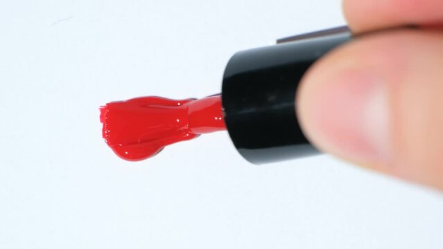 Red nail polish stroke on white background, polish texture, top view