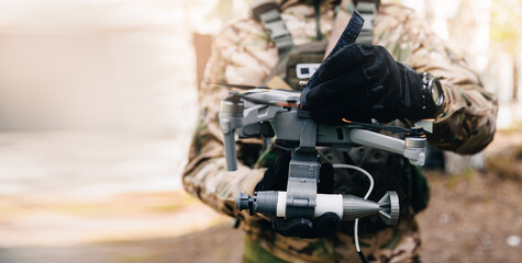 Modern drone with reset device for bomb in hands of soldier army. Concept military UAV use in war, banner