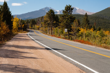 Mountain roadway, Highway 7, through the changing colors of aspens on an autumn morning at Lily Lake Visitor Center, Rocky Mountain National Park, Colorado