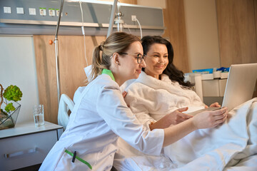 Obraz premium Brunette lady communicates online in a hospital room