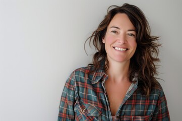 Fototapeta premium Portrait of a smiling woman in her 40s dressed in a relaxed flannel shirt isolated on white background