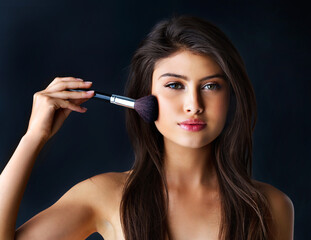 Obraz premium Woman, portrait and brush for makeup in studio for beauty glamour, salon and foundation product of transformation. Girl, facial tools and cosmetic routine with aesthetic and shine on black background