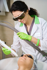 Specialist cosmetologist works with the face of a middle-aged patient