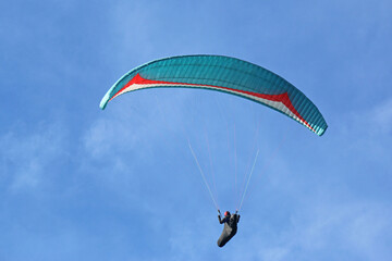 Paraglider flying in a blue sky