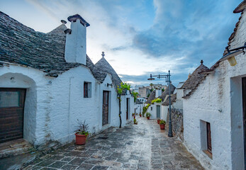 Trulli of Alberobello, Puglia, Italy. town of Alberobello with trulli houses among green plants and...