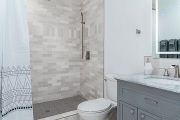 modern bathroom white with gray tile shower, cabinet, and sink