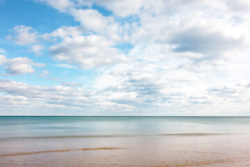 Partially cloudy, yet blue-sky day, moves over the calm wateers of Lake Michigan just off the beach at Harrington Beach State Park, Belgium, Wisconsin in early November
