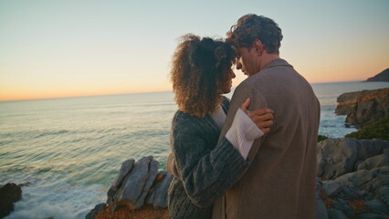 Curly girl embracing boyfriend at evening coast closeup. Lovers hugging together