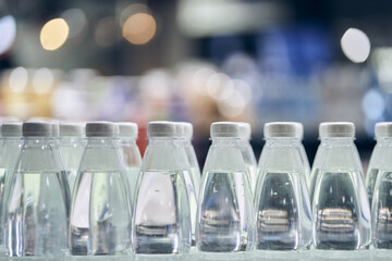 There are a lot of white caps from drinking water bottles and bottles with clean drinking water on a defocused background. With space to copy. High quality photo
