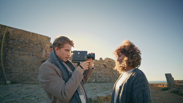 Smiling guy holding camera making vacation pictures closeup. Carefree newlyweds
