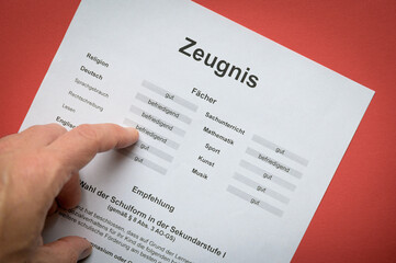 Finger zeigt auf Noten auf einem Schulzeugnis