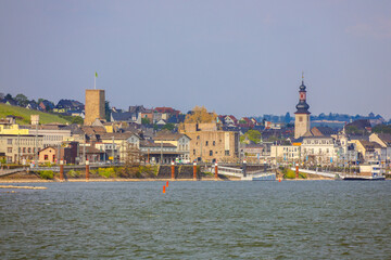 Obraz premium Rüdesheim am Rhein ist eine malerische Stadt, bekannt für ihre historische Altstadt mit charmanten Fachwerkhäusern und der berühmten Drosselgasse, die von Weinlokalen gesäumt ist. Oberhalb der Stadt t