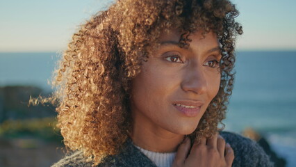 Closeup dreamy girl looking camera at ocean. Portrait african american woman